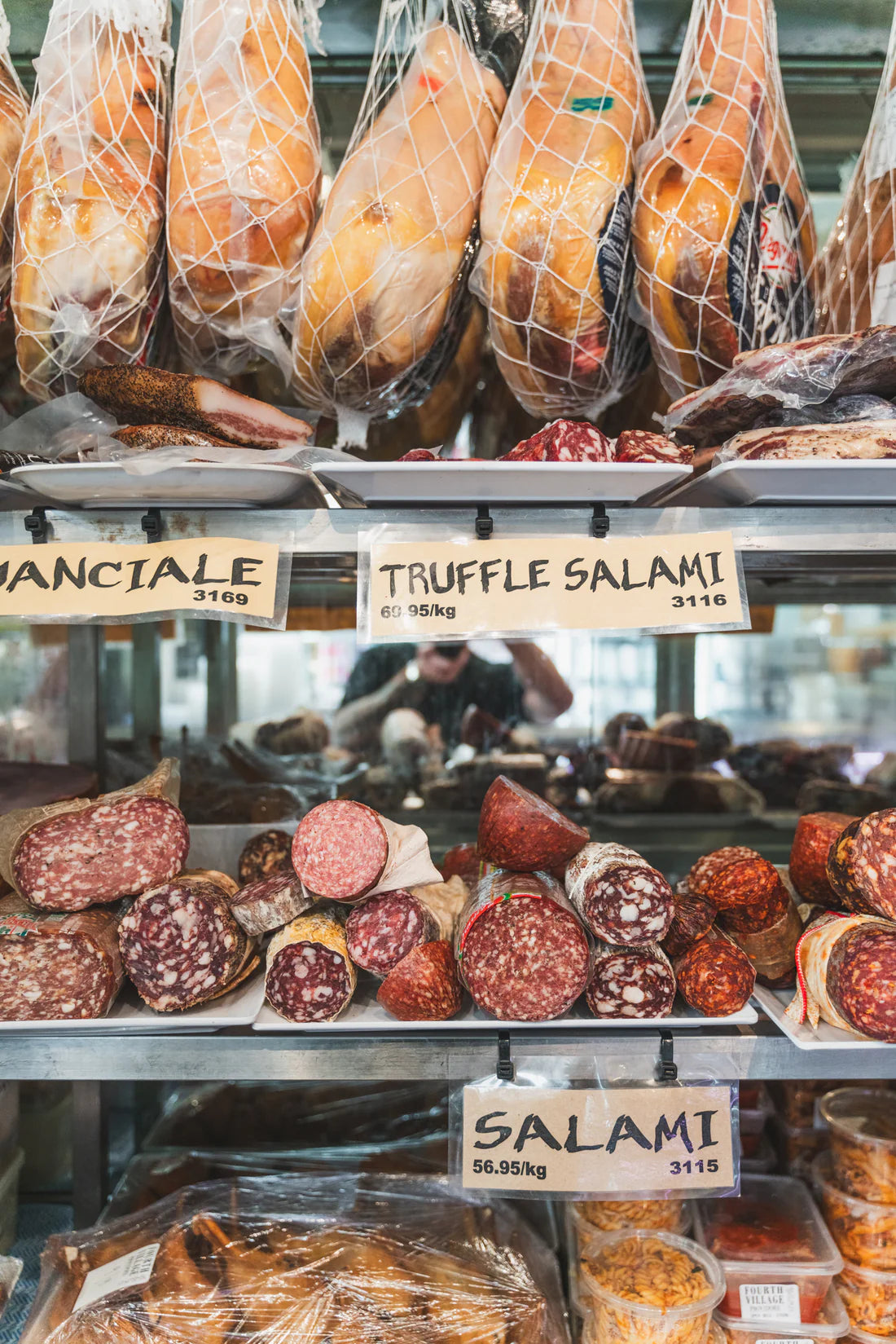 Display of various types of salami and cured meats in a store.